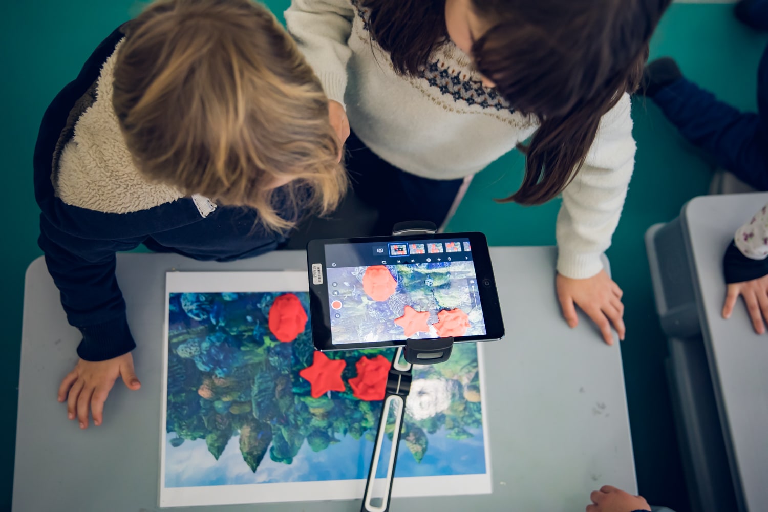 Deux enfants vus de haut réalisant une activité lors des Petits Ateliers