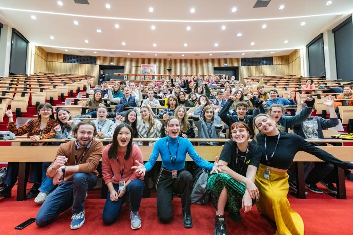 Photo de groupe dans amphithéâtre avec public scolaire et intervenant.e.s