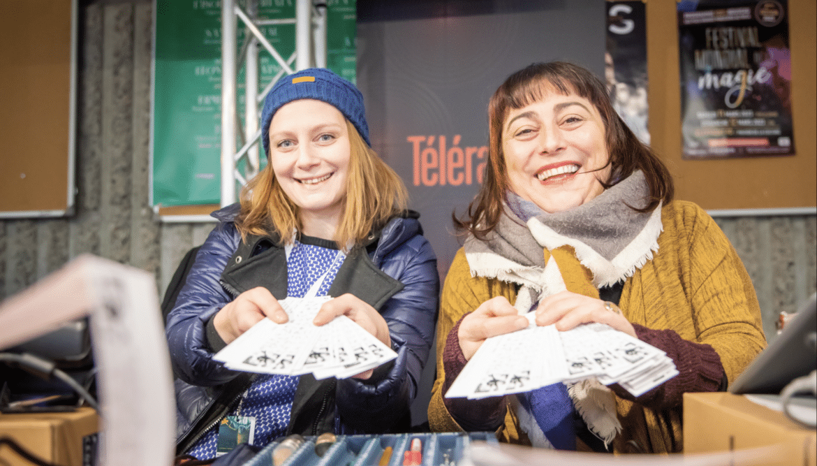 Des hôtesses d'accueil montrent les billets d'entrée du festival
