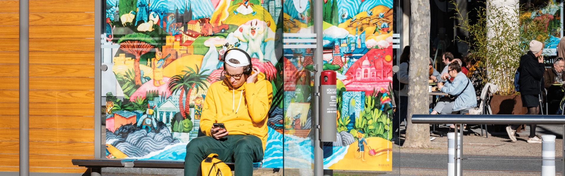 Une personne attend assis à l'arrêt de tramway