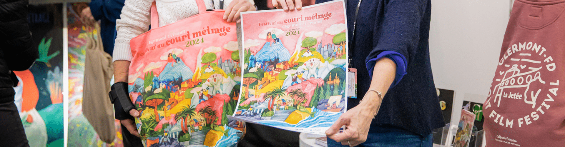 Des produits dérivés de la boutique du festival sont mis en avant : tote bag, affiche et hoodie