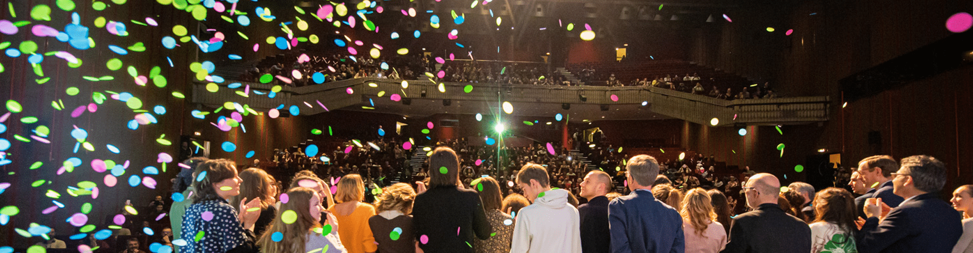 Des lauréat·e·s, remettant·e·s et juré·e·s de dos, sur la scène de Cocteau, pendant la photo finale, sous les confettis, durant la cérémonie de clôture
