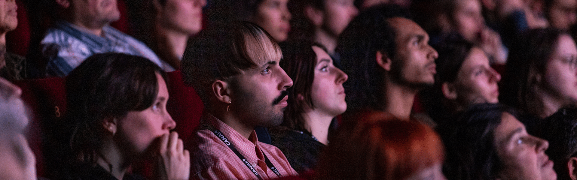 Une partie des juré·e·s étudiants 2024 regardent un film dans la pénombre de la salle Cocteau