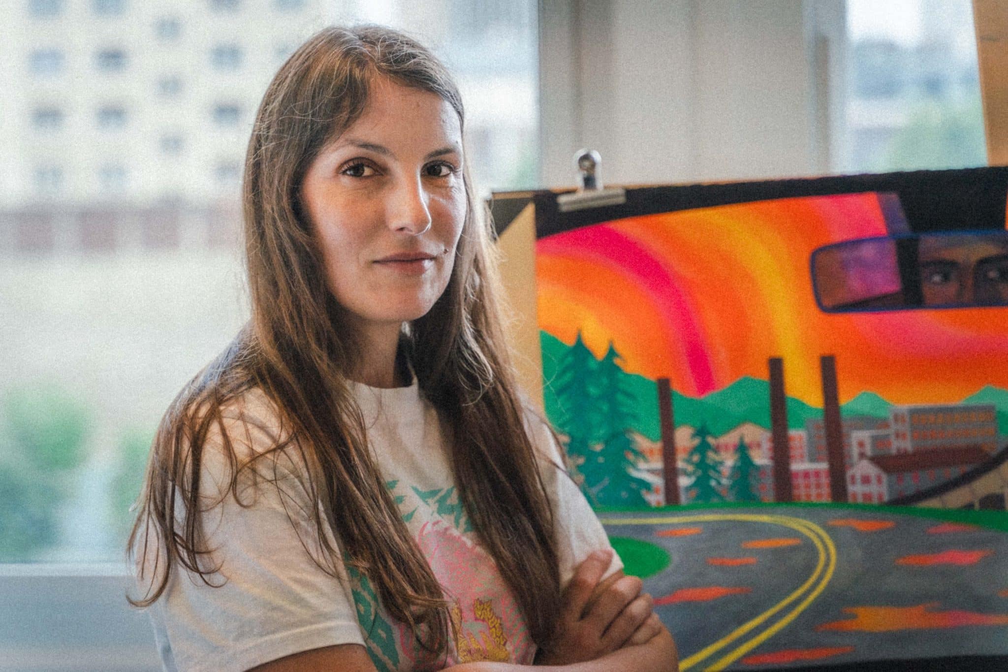 L'illustratrice Marie Larrivé prend la pose devant l'affiche du festival 2025 © Abigaëlle Robineau