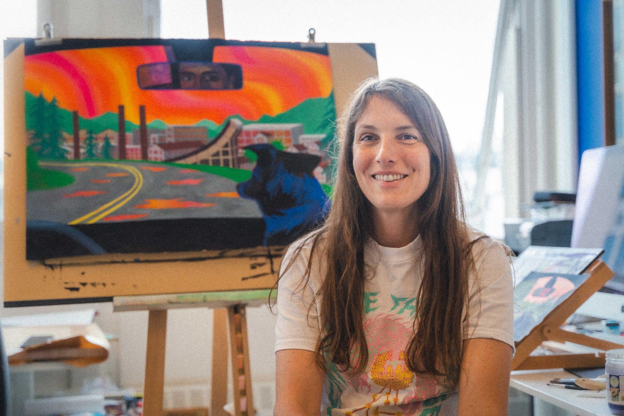 L'illustratrice Marie Larrivé prend la pose devant l'affiche du festival 2025 © Abigaëlle Robineau