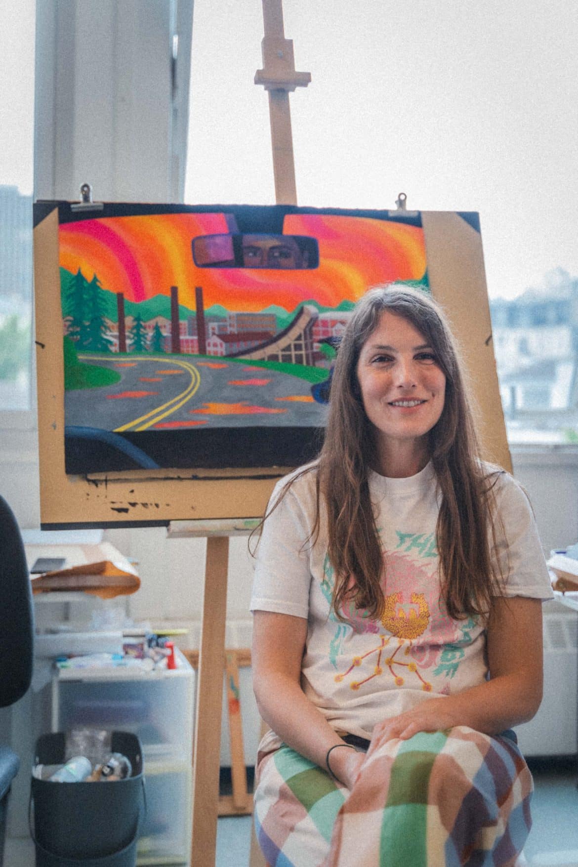 L'illustratrice Marie Larrivé prend la pose devant l'affiche du festival 2025 © Abigaëlle Robineau