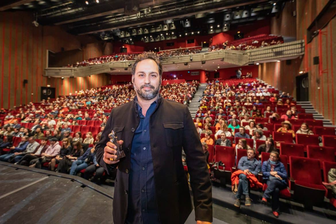 Wissam Charaf, réalisateur du film "Et si le soleil plongeait dans l'océan des nues", prix spécial du jury national 2024, sur la scène Jean Cocteau avec son trophée Vercingétorix