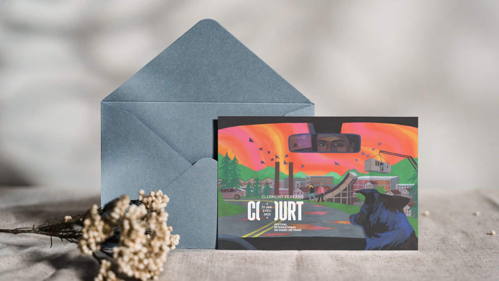 Carte postale du festival 2025 devant une enveloppe